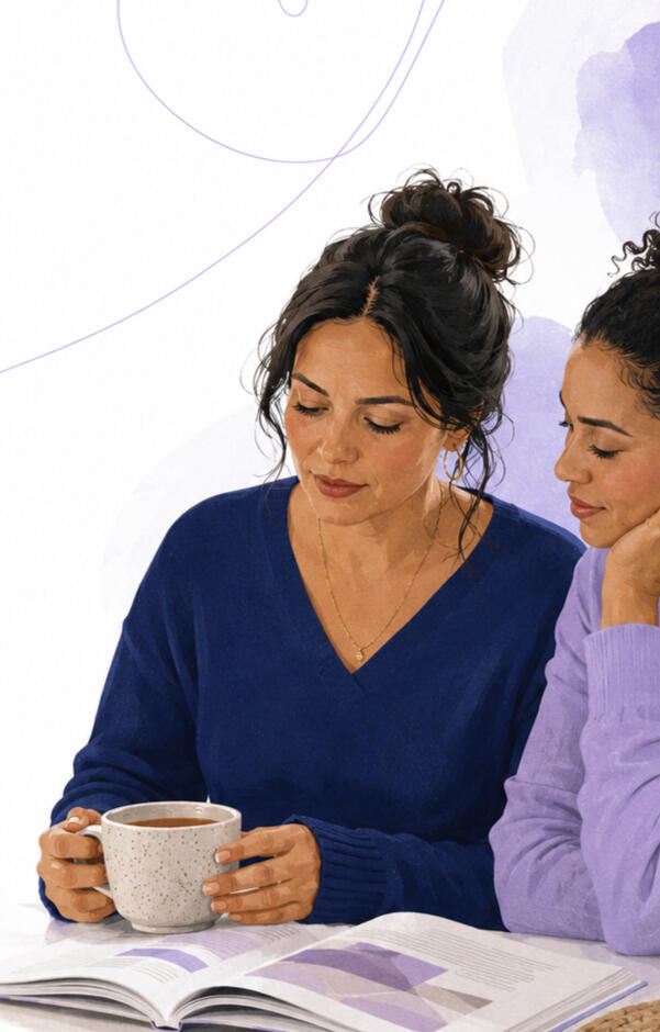 Two women sitting together and reading a family resource